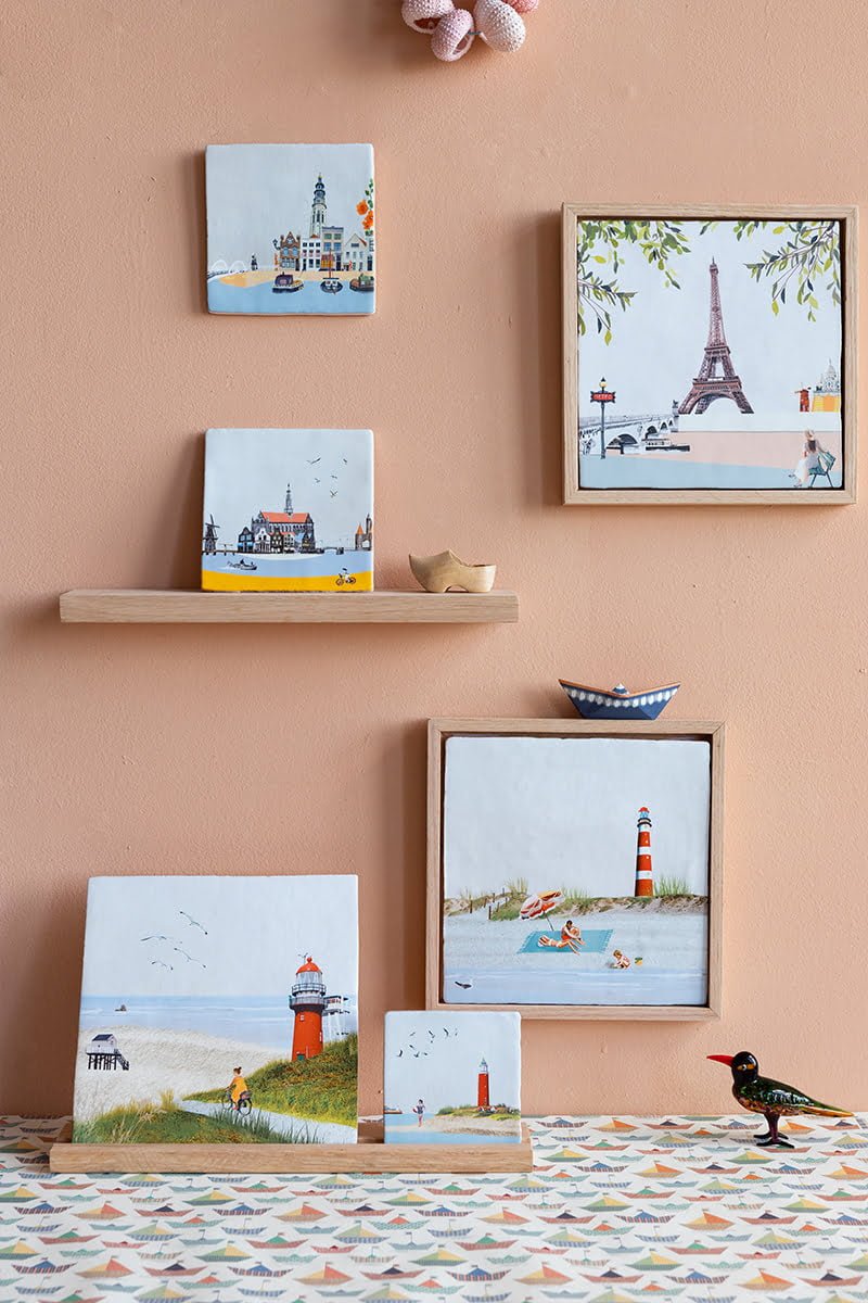 Tegeltjes verschillende steden en vuurtoren op pastelkleurige muur