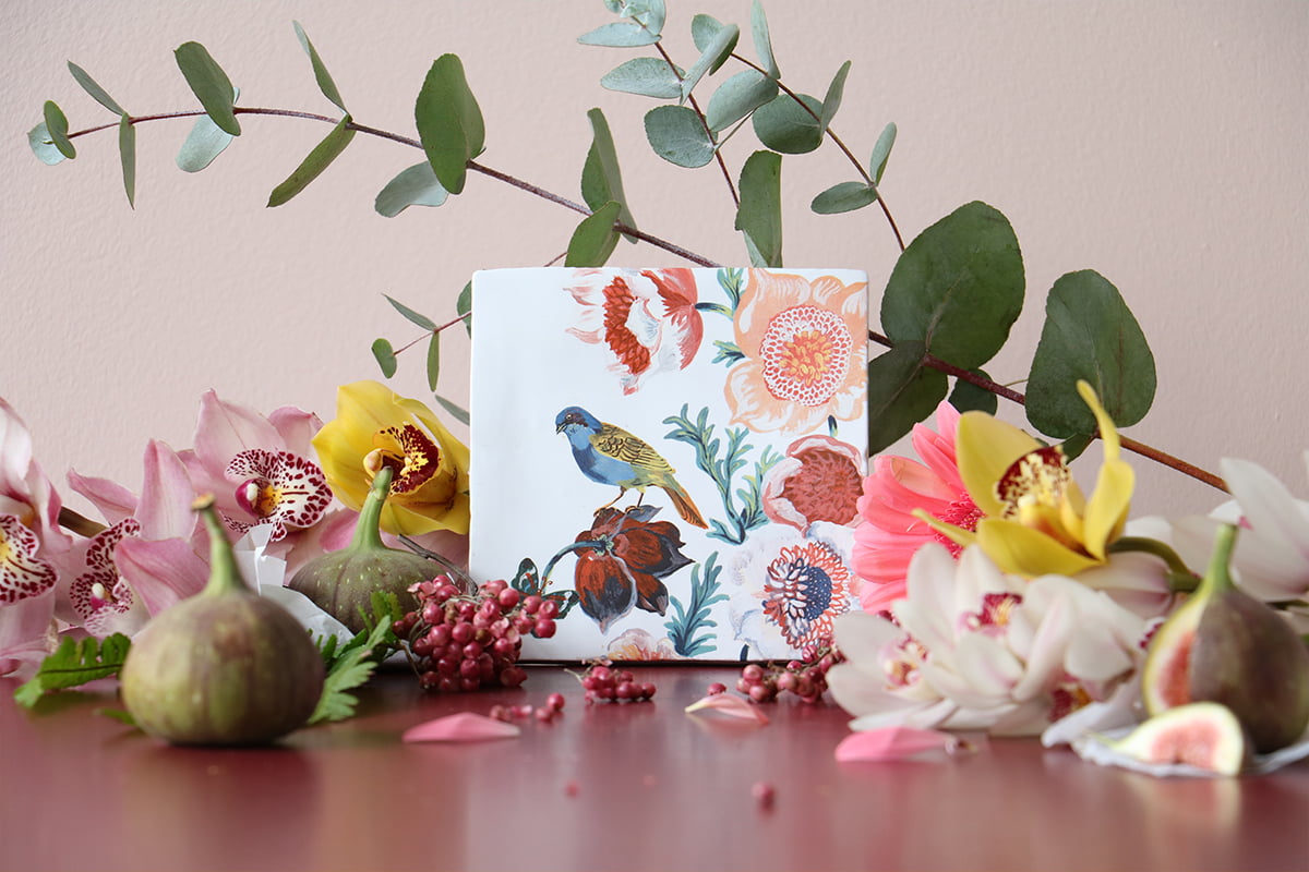 Tegeltje vogel natuur tussen kleurrijke bloemen en vruchtenexpositie