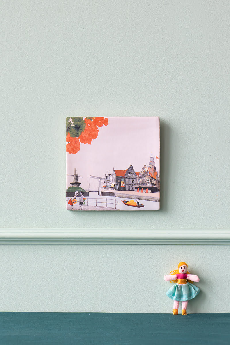 Tegeltje Alkmaar met bloemenmotief op pastelgroene muur