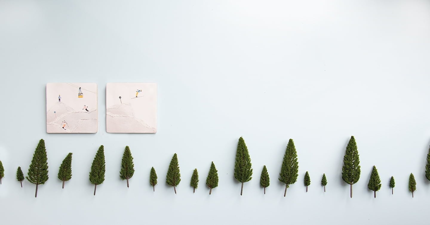 Tegeltje skiërs berglandschap minimalistische kunst boven miniaturen dennenbomen wand