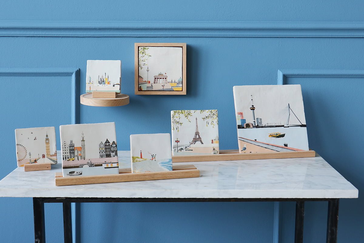 Tegeltjes met stadsgezichten op tafel en muurdisplay