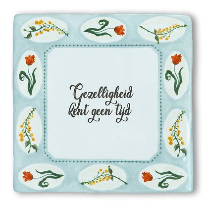 Tegeltje met bloemen en tekst, midden in blauw kader