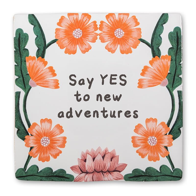 Tegeltje met oranje bloemen en inspirerende tekst in het midden