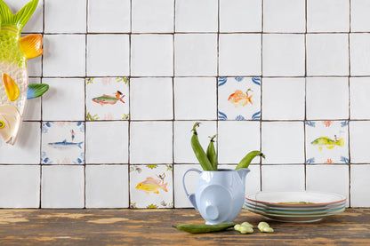 Witte tegels met kleurrijke vismotieven op keukenachtergrond