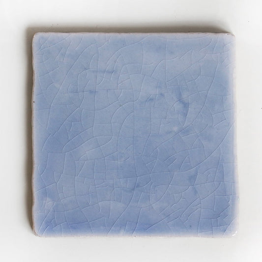 Blauw geglazuurd tegeltje met krakelé patroon op witte achtergrond