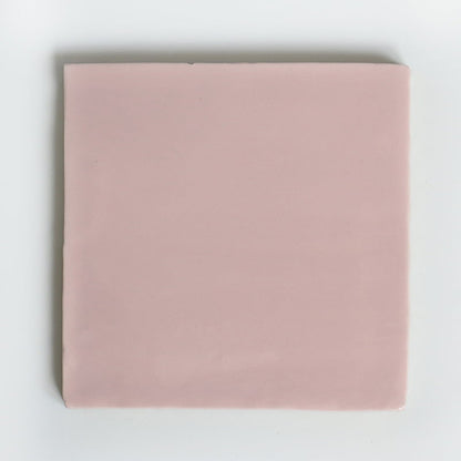 Roze vierkant tegeltje op een effen witte achtergrond geplaatst