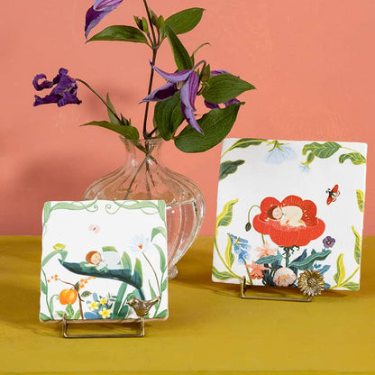 Tegeltjes met illustraties van kindjes in bloemen, kleurrijk gepresenteerd