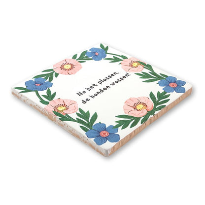 Tegeltje met bloemen en handwashingsadvies in hoekperspectief gepresenteerd