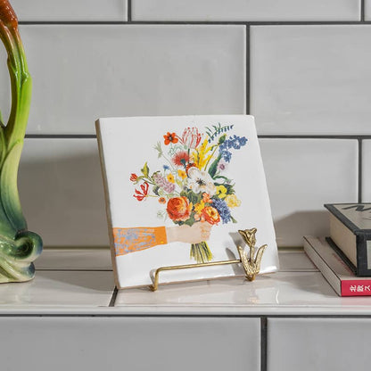 Gouden tegelhouder in bloemenmotief op een wandplankje