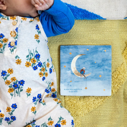 Geboortetegel kind op maan, naast baby op kleed