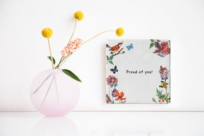 Tegeltje met bloemen en vogels aan de muur
