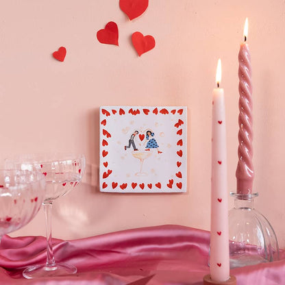 Gepersonaliseerd tegeltje met hartjes omringd door romantische decoratie
