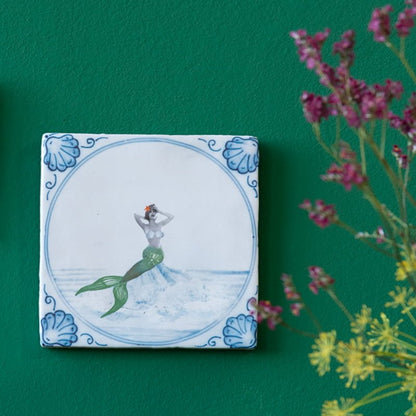 Delfts blauw tegeltje met zeemeermin op groene muur