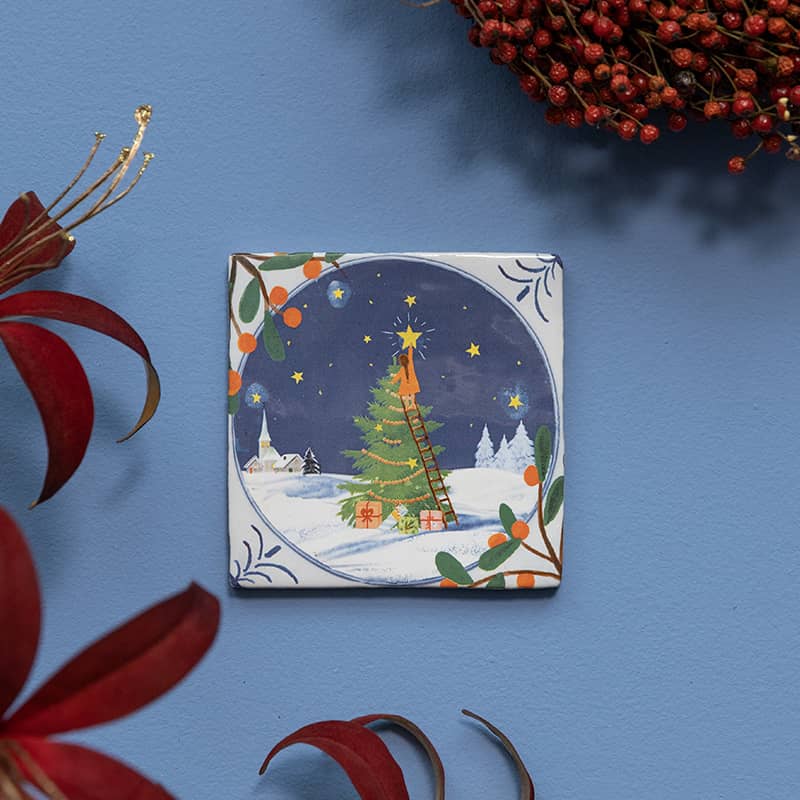 Kersttegeltje meisje ster ophangt groene boom besneeuwde achtergrond nacht