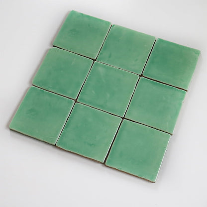 Groene vierkante tegels liggen in een grid op wit oppervlak