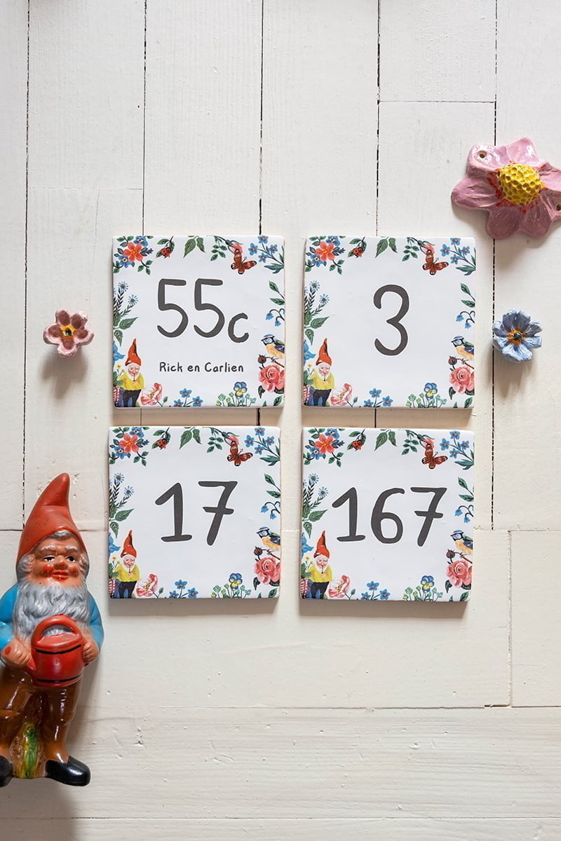 Huisnummer tegeltje met kabouters en bloemen, liggend op witte achtergrond