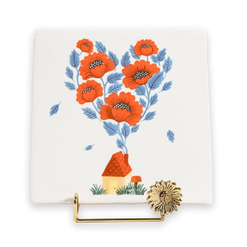 Gouden tegelhouder met bloemendecor op wit oppervlak