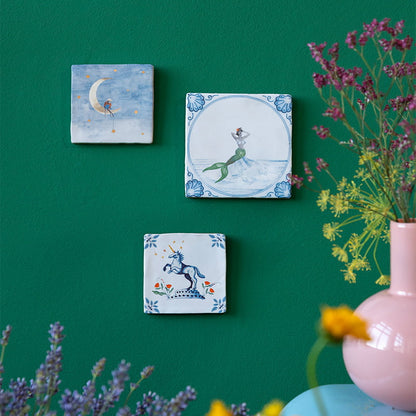 Delfts blauw tegeltje met zeemeermin tegen groene muur gepresenteerd