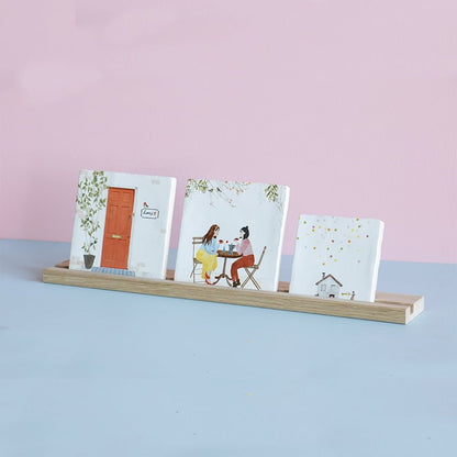 Tegelhouder met drie tegels op houten plank, roze achtergrond