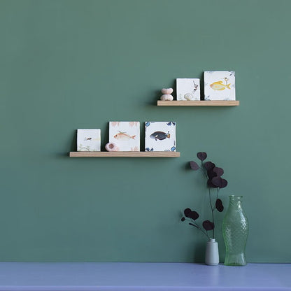 Wandplankjes met tegeltjes en decoraties tegen groene muur