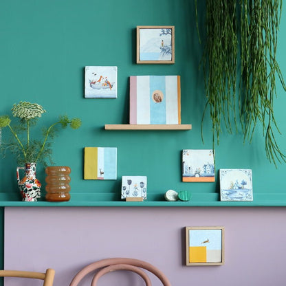 Geslaagd cadeau tegeltje diverse kunstwerken aan groene muurdisplay