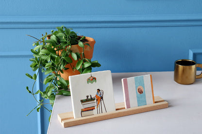 Geslaagd cadeau tegeltje boekenlezer presenteert op tafel met plant