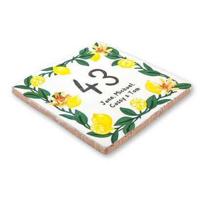 Huisnummer tegeltje met gele bloemen en groene bladeren versierd