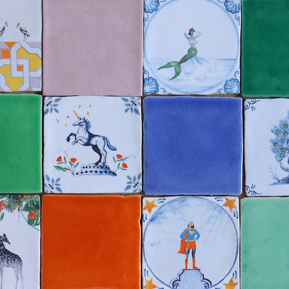 Delfts blauw tegeltje met eenhoorn tussen kleurrijke vierkante tegels