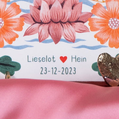 Gepersonaliseerd tegeltje met namen en bloemen, tegen roze achtergrond