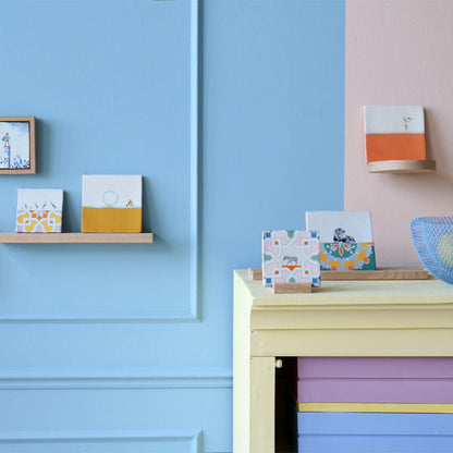 Tegeltje met patroon op houten plank tegen blauwe muur