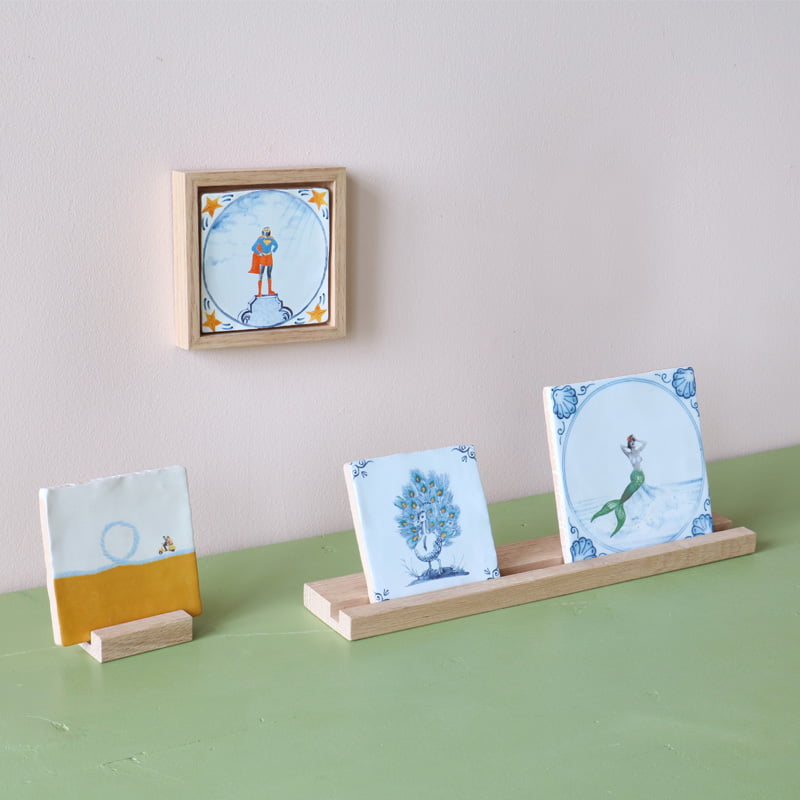 Gepersonaliseerde tegels met diverse figuren, gepresenteerd op houten standaards
