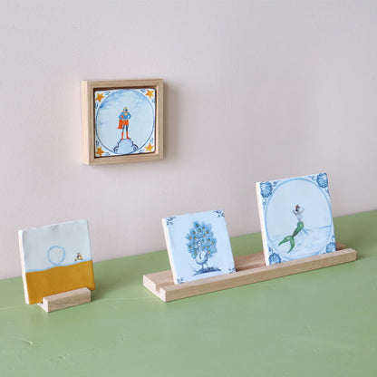 Gepersonaliseerde tegels met diverse figuren, gepresenteerd op houten standaards