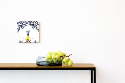 Tegeltje met zittend persoon boven tafel met groene druiven