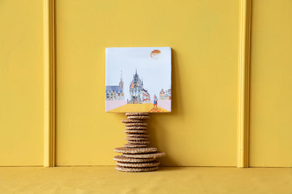 Tegeltje Gouda opgestapeld op stroopwafels tegen okergeel achtergrond