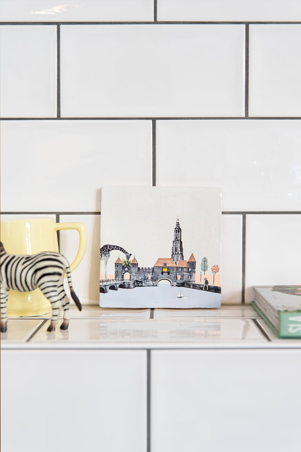 Tegeltje Amersfoort keuken tegen witte betegelde muur