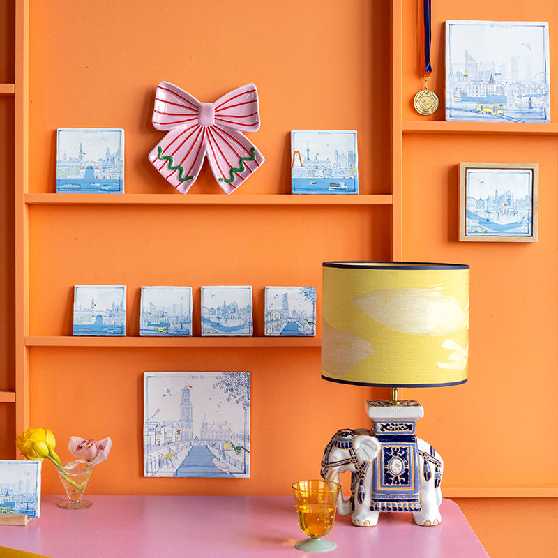 Haarlem, Den Haag, Rotterdam, Amsterdam en Utrecht als Delfts blauwe stadstegels aan een oranje wand