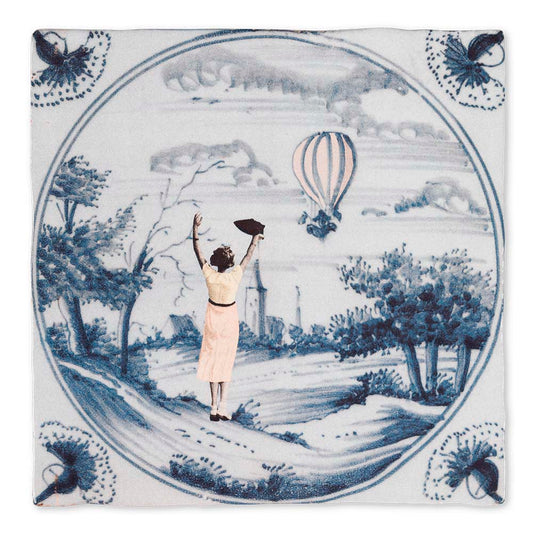 Tegeltje met vrouw die luchtballon bewondert in landschap