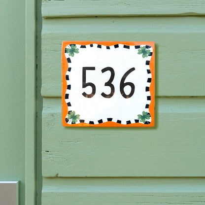 Huisnummertegeltje oranje met klavertje vier van Storytiles