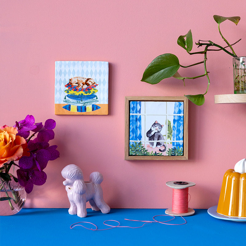 Tegeltje slapende hond en zich wassende kat naast elkaar