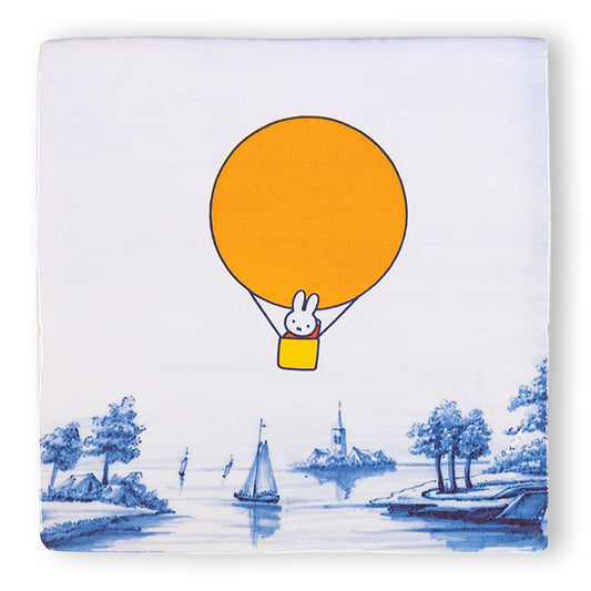 Tegeltje met nijntje in een oranje luchtballon zwevend boven Delfts Blauw landschap