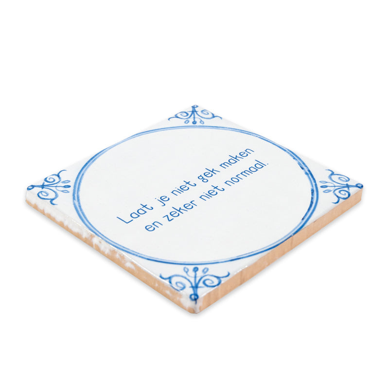 Typical Delft Blue tegeltje liggend op witte ondergrond