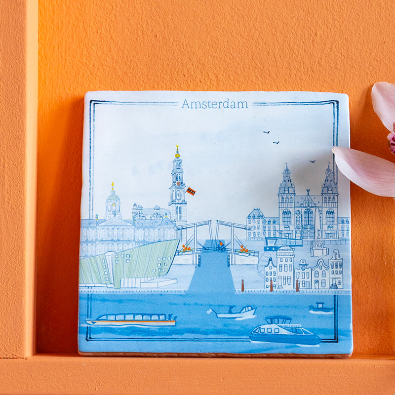 Stedentegel Amsterdam in delfts blauw tegel een oranje wand