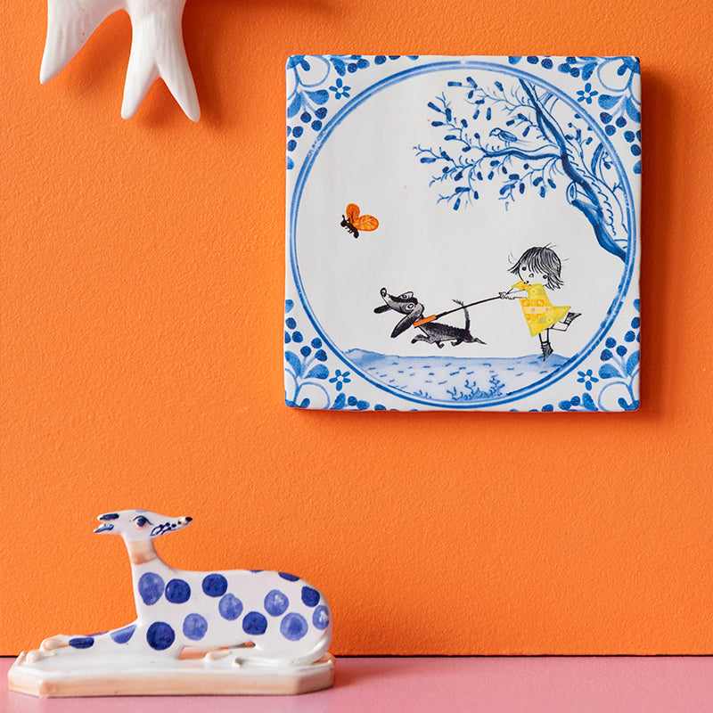 StoryTile Beste vriendjes van meisje dat haar hond uitlaat hangend aan een oranje muur