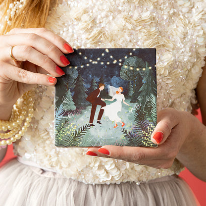 Bruid houdt met roodgelakte nagels de StoryTile Our wedding night vast