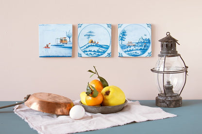 Delfts blauwe StoryTiles tegeltjes met schilderingen van landschap, aan de muur
