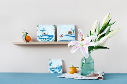 Delfts blauwe StoryTiles tegeltjes met natuurmotieven, gepresenteerd op houten plank
