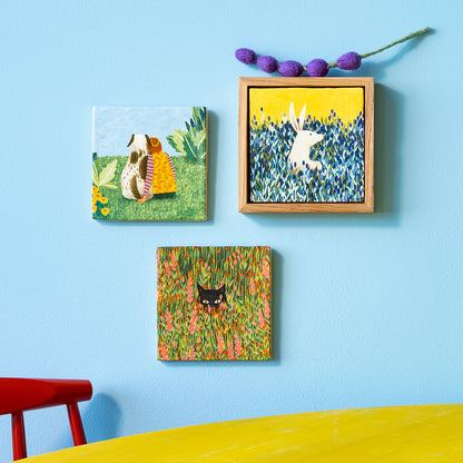 Hondentegel en tegels met haas en kat in groepje opgehangen op lichtblauwe wand