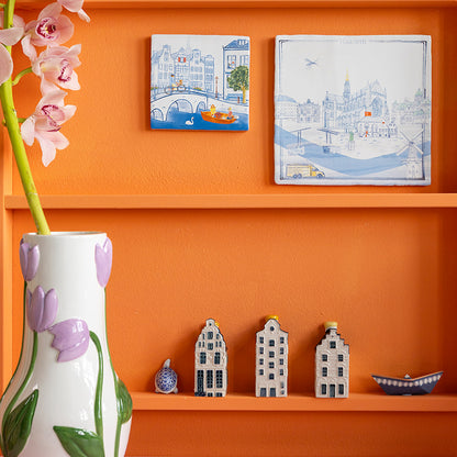 Delfts blauwe Haarlem stedentegel op een oranje muur gehangen