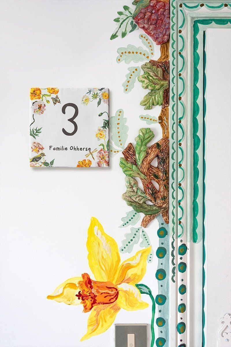 Huisnummerbordje met goudhaantje en kleurrijke bloemen
