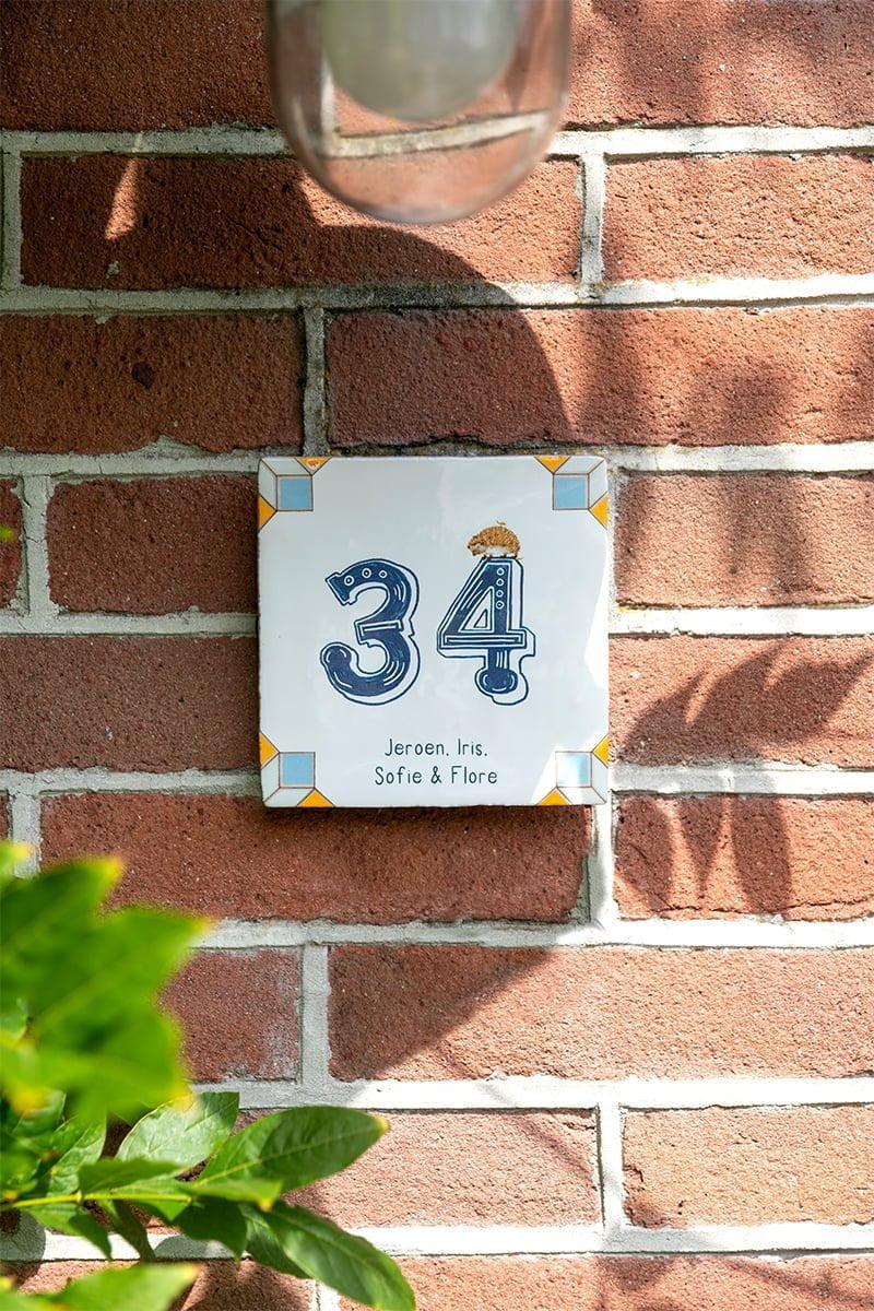 Huisnummer tegeltje met een egel en groot blauw huisnummer